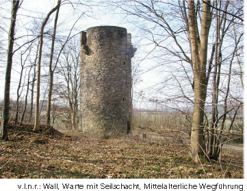 Die Roringer Warte heute: runder Steinturm im Wald, davor Wall und mittelalterlicher Weg